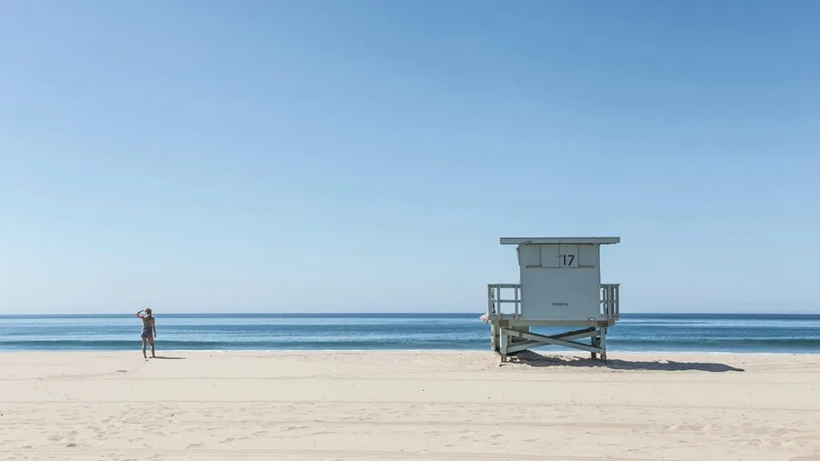 Rettungsschwimmerturm an einem menschenleeren Strand, ruhige See