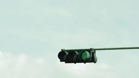 Nahaufnahme einer Ampel vor hellem Himmel, die auf Grün geschaltet ist