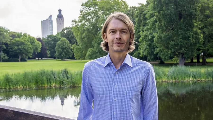 Evergreen-Gründer Iven Kurz im Park, im Hintergrund das Leipziger Uniriesen-Hochhaus